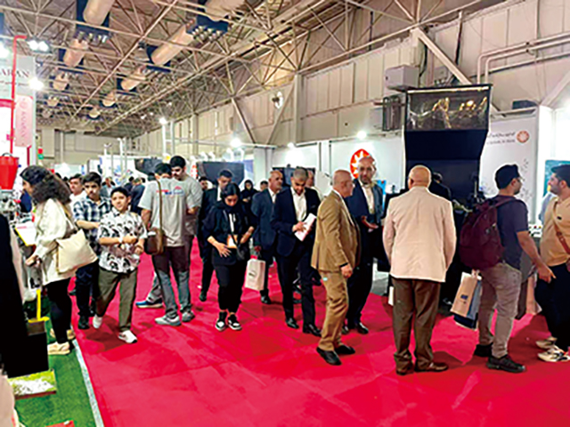 5.展館主通道人流密集，多位西裝革履的采購(gòu)商正在觀看產(chǎn)品演示